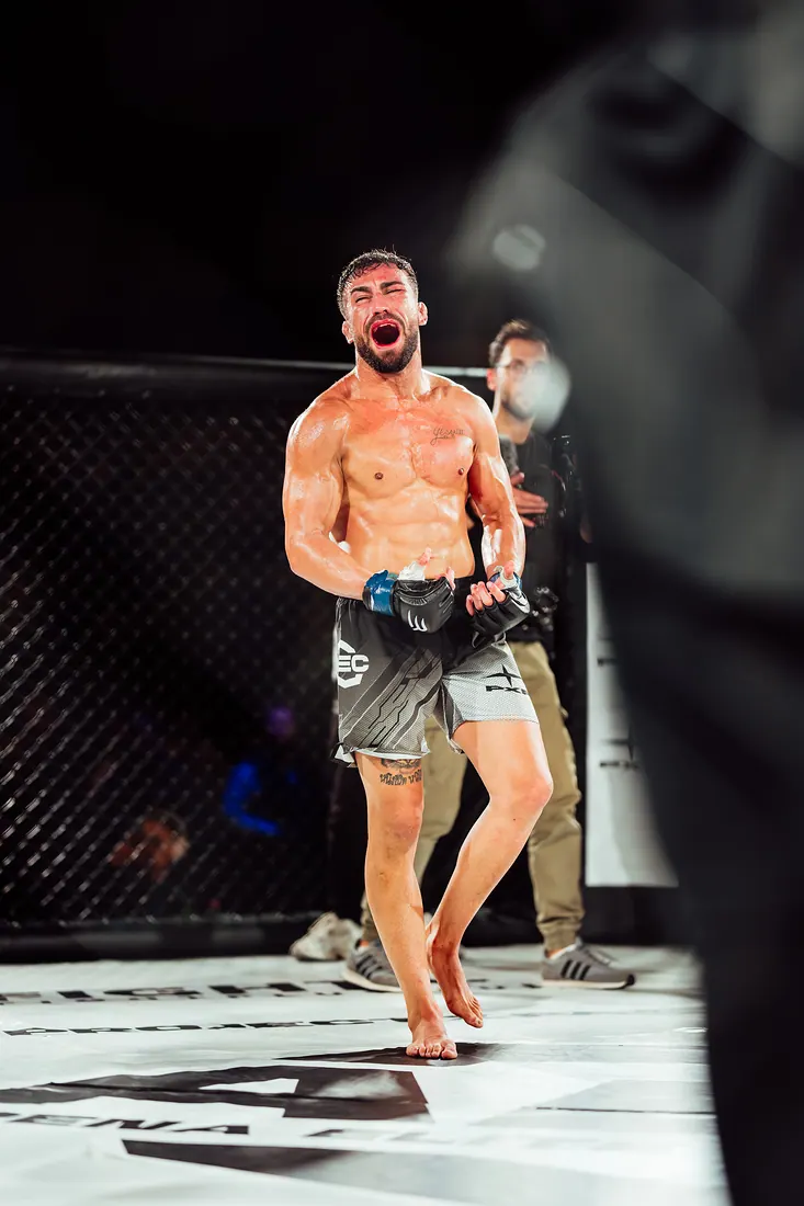 Combattant de MMA célébrant sa victoire dans la cage
