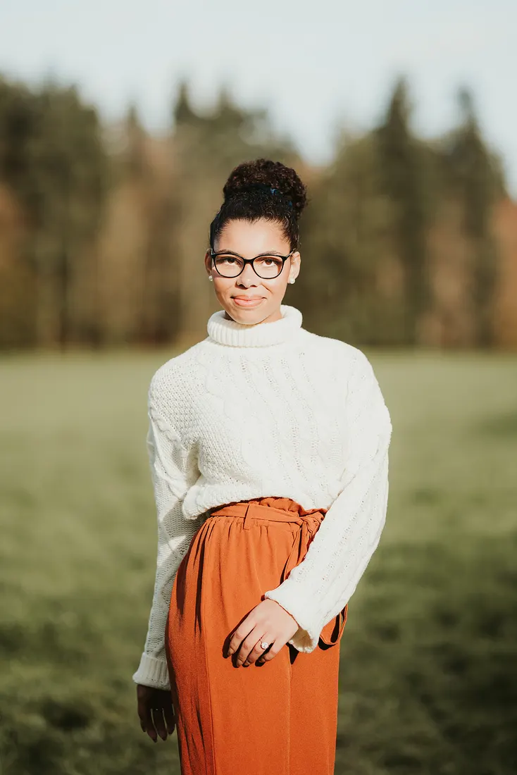 Portrait d’une femme en pull blanc dans un champ